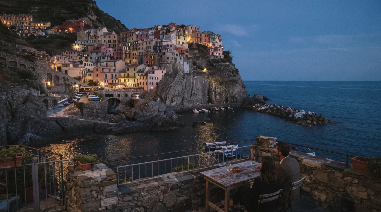 Cinque Terre village houses lit up above the harbour after sunset