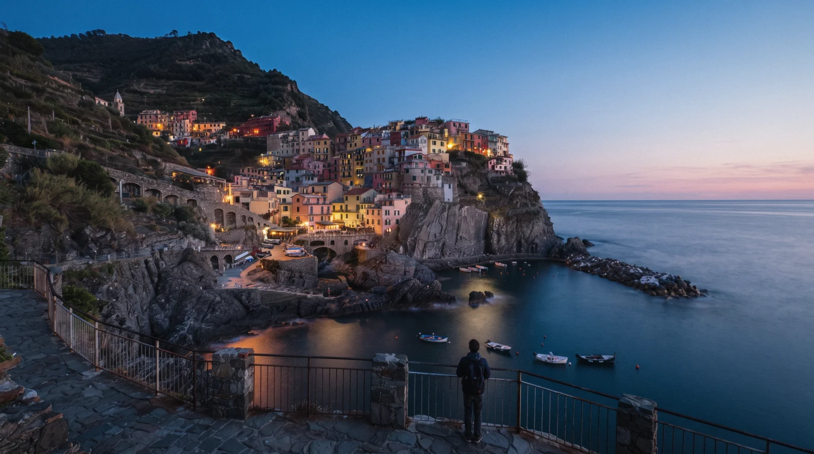 Manarola houses stacked above the rocky inlet at dusk, Cinque Terre, Italy