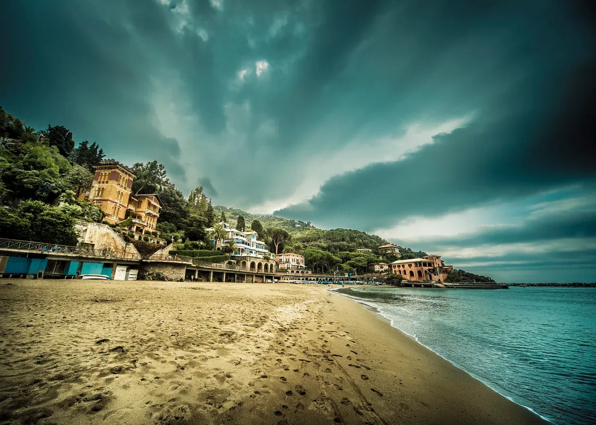 The sandy town beach at Levanto with pastel seafront villas along the shore, Italy